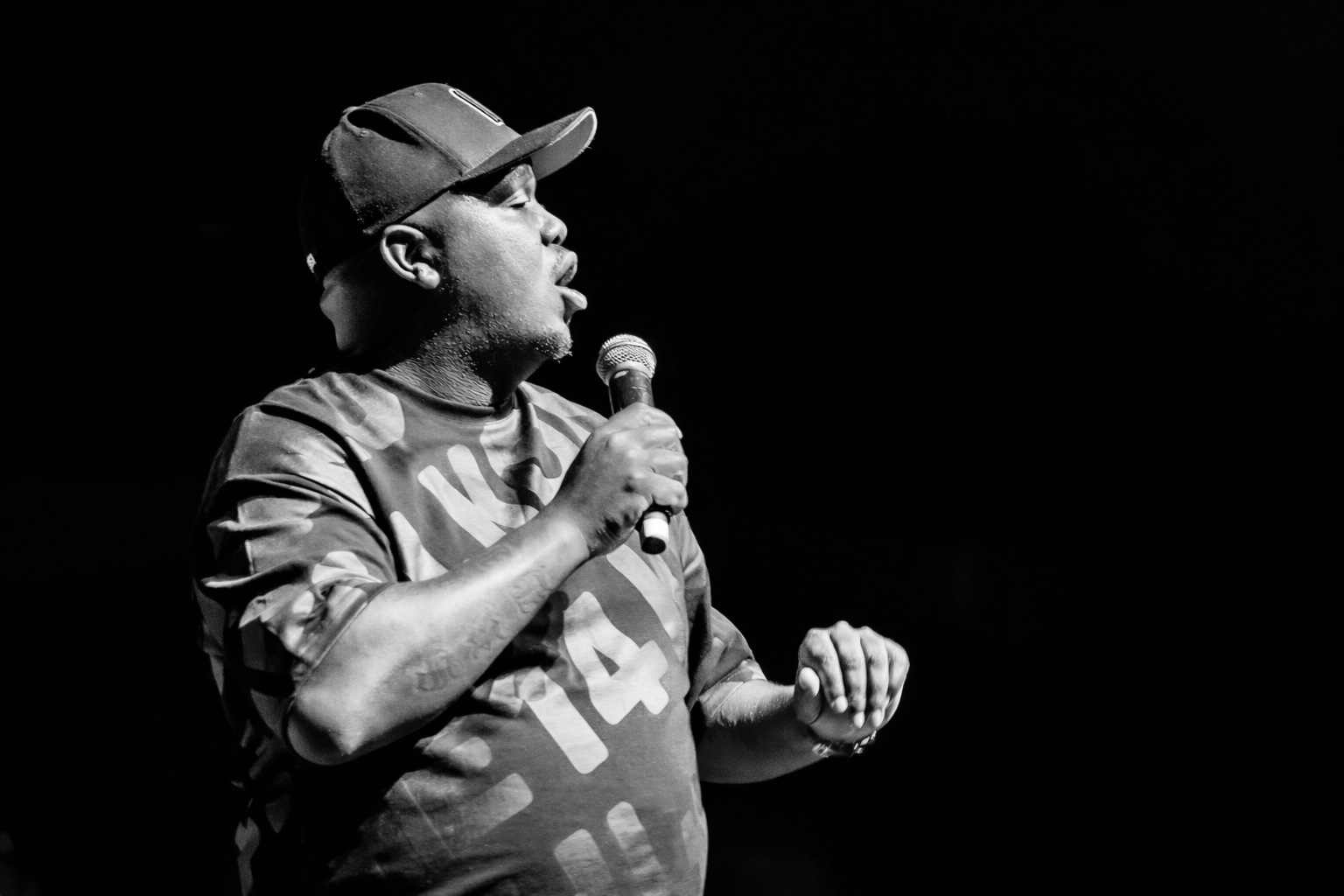 Portrait of Skhumba Hlophe holding a microphone on stage